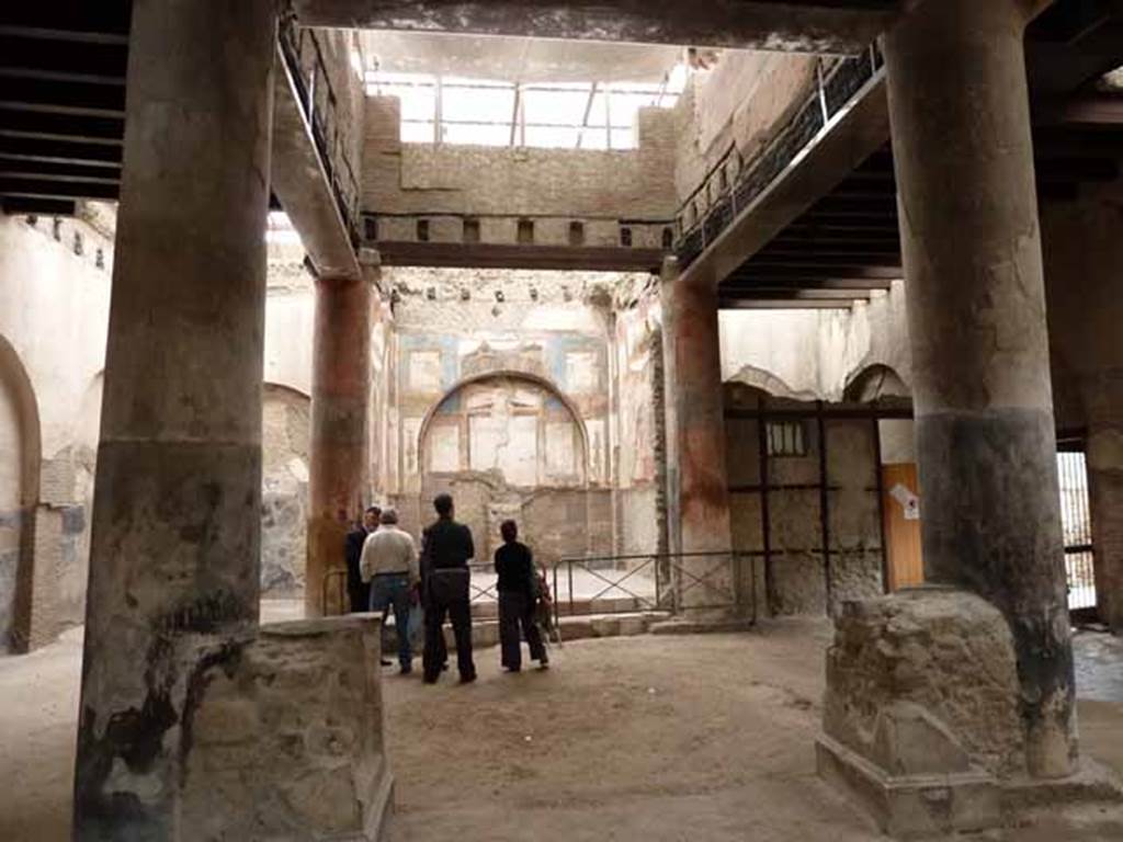 VI.21, Herculaneum. May 2010. Looking south towards shrine, across two statue bases between the first two columns, as you enter.